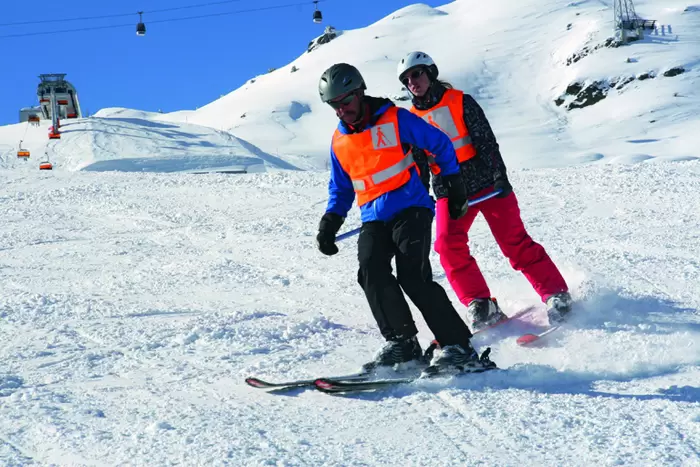 Skifahrer-Tandem beim Üben auf der Piste