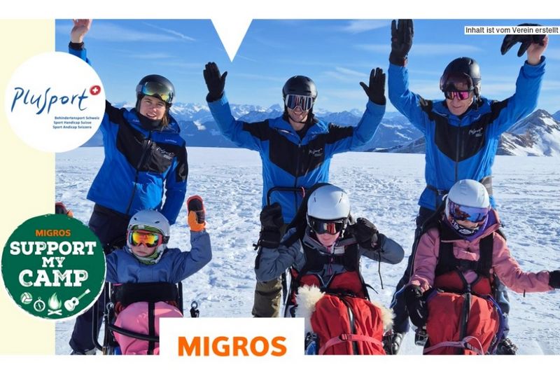 Fünf Personen in Wintersportausrüstung, einige auf Sitzskiern, andere im Stehen, lächeln und heben ihre Arme auf einem verschneiten Berg. Das Bild enthält die Logos von PluSport und Migros Support My Camp.