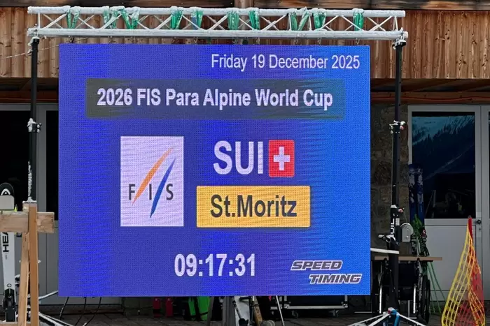 Ein elektronisches Schild zeigt Details für den FIS Para Alpinen Weltcup 2026 in St. Moritz, Schweiz, mit dem Datum Freitag, 19. Dezember 2025 und der Uhrzeit 09:17:31. Die Logos von FIS und Speed Timing sind sichtbar.