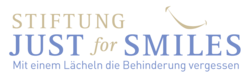 Logo der Stiftung Just for Smiles mit einer Lächelgrafik und dem Slogan Mit einem Lächeln die Behinderung vergessen darunter.
