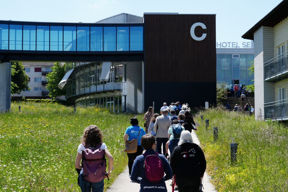 Eine Gruppe von PluSport-Delegierten laufen auf einem Fussweg zum Hotel Sempachersee.